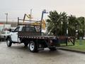 A 2008 Sterling Bullet flatbed truck with a wooden stake body and rear safety rails is parked on a concrete surface