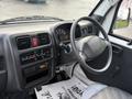Interior view of a 2009 Suzuki Carry showing the dashboard steering wheel and control panel with various dials and buttons