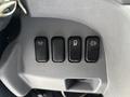 A close-up view of four black control buttons on the dashboard of a 2015 Mitsubishi Fuso FE160 truck