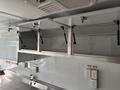 Interior of a 2020 Freightliner MT45 showing open overhead storage compartments and electrical outlets mounted on the walls