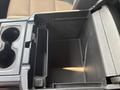 A center console with a divided storage area and two cup holders in a 2017 Chevrolet Silverado 1500