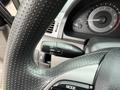 Close-up of a textured steering wheel with a turn signal and headlight control stalk on the left side showing the dial positions