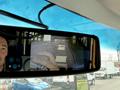 A 2020 Chevrolet Express viewed through a rearview mirror with a person's hand visible holding a remote control