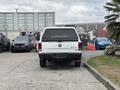 A white 2013 RAM 1500 pickup truck with a black top and 4x4 insignia visible on the tailgate