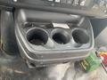 Cup holder in a 2016 Chevrolet Express with three compartments dirty and filled with debris