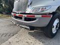 A 2012 International DuraStar 4300 with a silver front exterior featuring a prominent grille and a chrome bumper with visible towing hooks