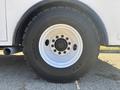 A close-up of the wheel of a 2005 Freightliner M2 106 featuring a white rim and a large black tire labeled with the size and brand