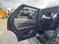 A 2015 Dodge Durango with an open front door revealing the interior featuring black leather seats and modern dashboard controls