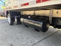 A black fuel tank mounted underneath a 2018 Hino 195 truck with visible metal fittings and attachments