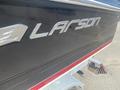 Close-up of a 2013 Larson 238 boat showing the silver logo on the side with the word Larson in bold lettering