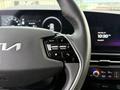 Close-up of the steering wheel of a 2023 Kia Niro EV featuring control buttons for driving modes and multimedia functions