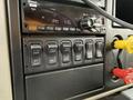 Dashboard controls of a 2016 International 7600 featuring a radio display and several toggle switches for vehicle functions