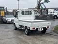 A white 2008 Suzuki Carry pickup truck with a cargo bed and a compact design facing slightly to the right