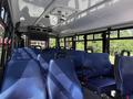 Interior of a 2020 Chevrolet Express with blue upholstered seats arranged in rows and a central aisle