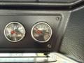 Close-up of dashboard gauges in a 2010 Autocar Xpeditor showing readings for rear axle and traction application pressure