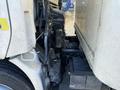 Close-up view of a white 2014 Hino 195 truck showing the engine compartment with visible components and battery near the front wheel
