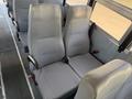 Two gray bus seats with vertical ribbed patterns and seatbelts located in the interior of a 2009 International 3000 CE bus