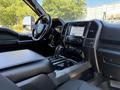 Interior view of a 2018 Ford F-150 showcasing the dashboard with touchscreen display and console with gear shifter and controls