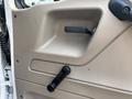 Interior door panel of a 2006 Sterling Acterra with a black door handle and a manual window crank in a beige finish