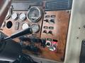 Dashboard of a 2008 Peterbilt 340 featuring gauges switches and a key ignition with a wood grain finish