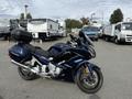 A 2016 Yamaha FJR1300AE motorcycle in dark blue with a touring seat and a top case mounted on the rear