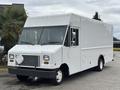 A white 2018 Ford Econoline delivery truck with a boxy shape and large front windows parked with no visible logos or branding