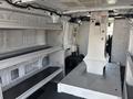 Interior view of a 2019 Ford Transit 350 with metal shelving units on both sides and a central platform for cargo storage