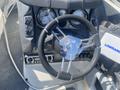 The cockpit of a 2013 Larson 238 featuring a steering wheel with a chrome center and black grip along with multiple gauges and control panels