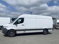 A white 2024 Mercedes-Benz Sprinter van with a high roof and no visible windows on the sides is parked on a lot