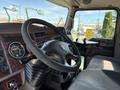 Interior of a 2009 Kenworth T270 with a large steering wheel dashboard gauges and controls for maneuvering the truck