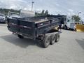 A black 2014 PJ 16 Foot Dump Trailer with a flatbed and three axles visible from the rear angle