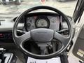 The interior view of a 2009 UD Trucks UD 3300 with a steering wheel and dashboard featuring multiple gauges and controls