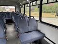 Interior of a 2018 Chevrolet Express showing rows of blue fabric seats with seatbelts and no passengers