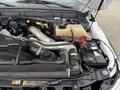 Close-up view of the engine compartment of a 2013 Ford F-450 SD showing various components like the turbocharger and battery with visible wires and hoses