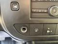 Close-up of the dashboard of a 2021 Chevrolet Express featuring buttons for audio controls and a port for auxiliary input