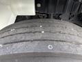 Close-up of a worn tire from a 2012 International DuraStar 4300 showing visible tread wear and small stones embedded in the rubber