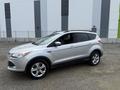 A silver 2014 Ford Escape with five doors and alloy wheels parked with its driver side facing the viewer