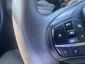 Close-up of a textured steering wheel with buttons for cruise control and settings in a 2020 Ford Explorer