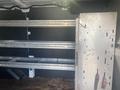 Interior of a 2017 Ford Transit van featuring metal shelving units and a metal partition on the right side