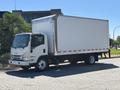 A 2022 Isuzu NQR box truck with a white cargo area and a sleek front end parked on a paved surface
