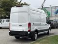 A white 2020 Ford Transit 250 cargo van with a tall boxy design and large rear doors parked in an outdoor area