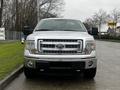 A silver 2014 Ford F-150 truck viewed from the front showcasing its distinctive grille and headlights