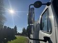 A 2005 Freightliner M2 106 truck with prominent side mirrors and clear visibility of its driver's side window