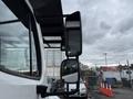 Close-up of a 2021 Freightliner M2 106 truck mirror with a clear reflection of surrounding vehicles and infrastructure