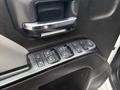 A close-up of the door control panel of a 2016 GMC Sierra 1500 showing buttons for window and lock controls