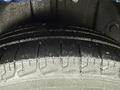 Close-up of a wet tire of a 2020 Dodge Grand Caravan showcasing the tread pattern and water droplets on the surface