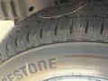 Close-up of a Bridgestone tire showing tread patterns and sidewall markings on a 2012 Ford Econoline
