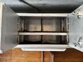 An open metal storage compartment with two horizontal dividers and a gray interior designed for a Workhorse W62 vehicle
