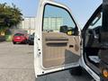 A 2009 Ford F-450 Super Duty with the driver's door open showing the beige interior and dashboard