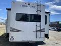 A 2021 Grand Design Recreational ST3478MBS travel trailer featuring a ladder on the back and the name "Solitude" prominently displayed